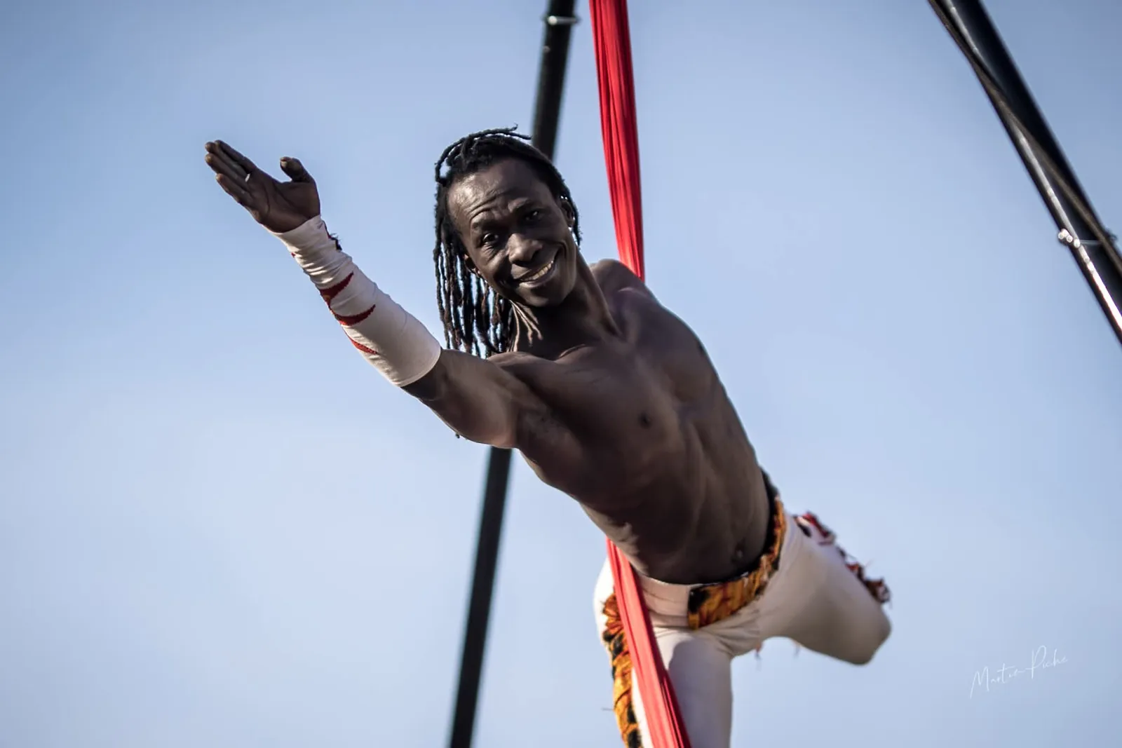 Sourire suspendu au tissu aérien rouge